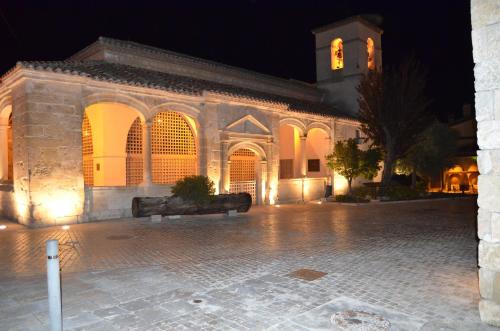 a large stone building with a clock tower at night at Hotel Rural Luna Llena in Torremocha de Jarama