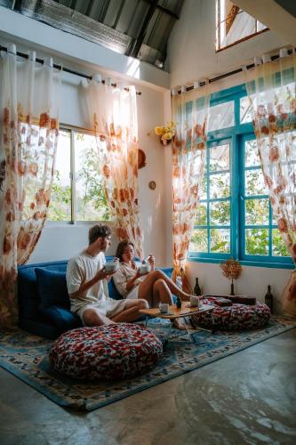 a man and woman sitting on a couch in a living room at Scenic Mountain Cabin with Workspace - Close to Ella in Badulla