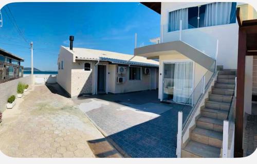 帕罗卡Ocean Residence - Aptos Pé na Areia Ponta do Papagaio的一座房子,在建筑物旁边设有楼梯