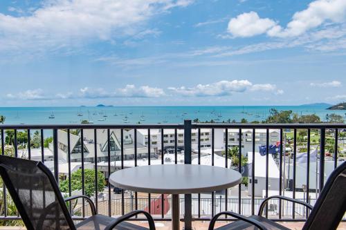a balcony with a table and chairs and the ocean at Ocean View Apartment 14 in Airlie Beach