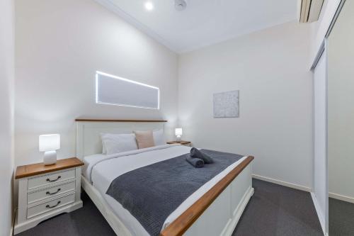 a bedroom with a bed with a cat sitting on it at Tropical Resort Apartment in Cannonvale