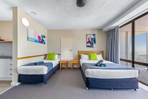 a hotel room with two beds and a table at Ocean View Studio 14A in Airlie Beach