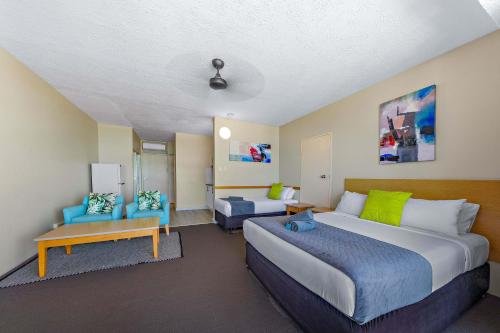 a hotel room with a large bed and a couch at Ocean View Studio 14A in Airlie Beach