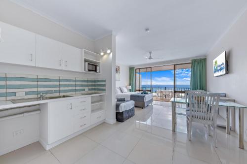 a kitchen and living room with a view of the ocean at Central Ocean View Studio 27a in Airlie Beach