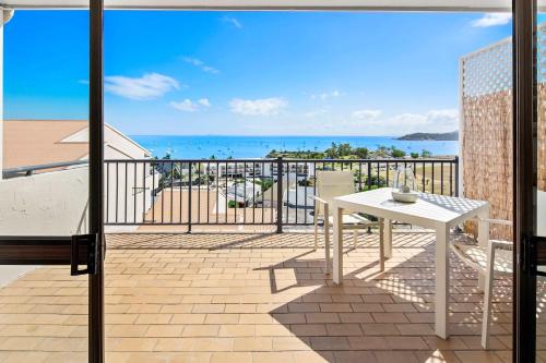 a balcony with a table and a view of the ocean at Ocean View Apartment 27 in Airlie Beach