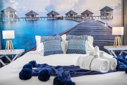 a bedroom with a bed with a boardwalk mural at Ocean View Apartment 27 in Airlie Beach