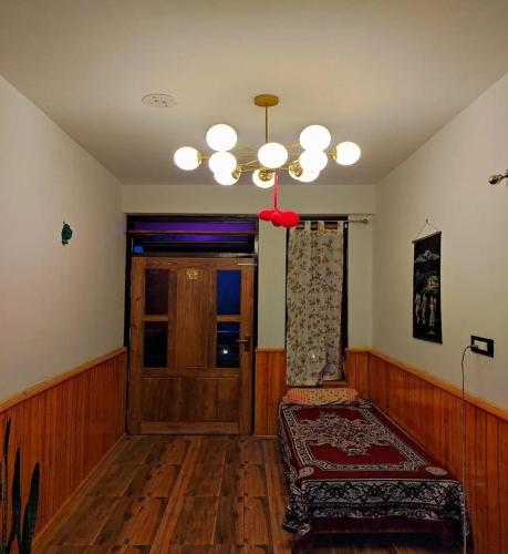 a living room with a chair and a chandelier at Wanderlust Homestay By StayApart in Kalimpong