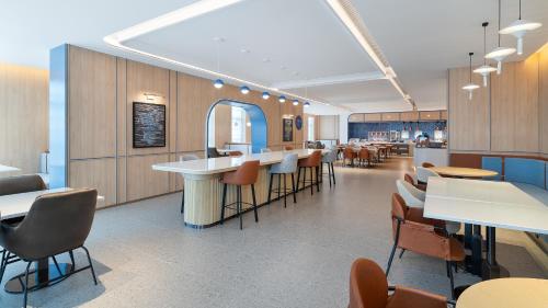 Un restaurante con mesas y sillas y una cafetería. en Holiday Inn Express Kunming Changshui Airport by IHG, en Kunming