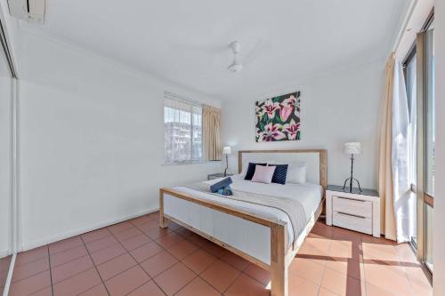ein weißes Schlafzimmer mit einem Bett und einem Fenster in der Unterkunft OCEAN VIEWS 10 in Airlie Beach