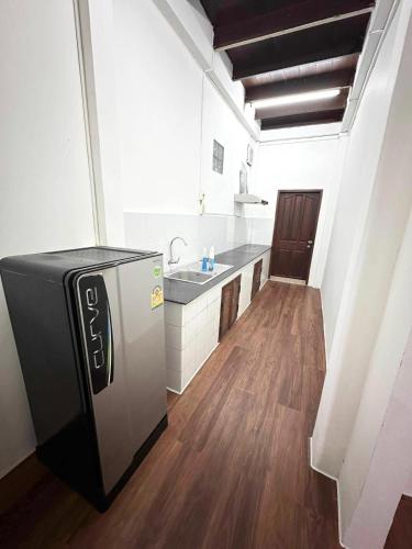 een keuken met een koelkast en een houten vloer bij Vientiane Semi detached house in Vientiane