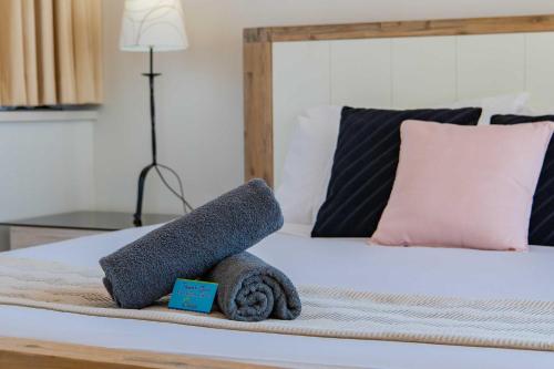 a bed with a pile of towels on it at OCEAN VIEWS 10 in Airlie Beach