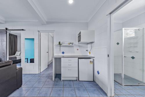 埃尔利海滩Airlie Sun & Sand Accommodation #3的配有白色橱柜和台面的厨房