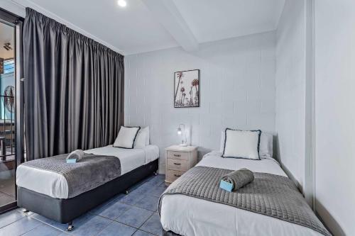 a bedroom with two beds and a window at Airlie Sun & Sand Accommodation #3 KIDS STAY FREE in Airlie Beach