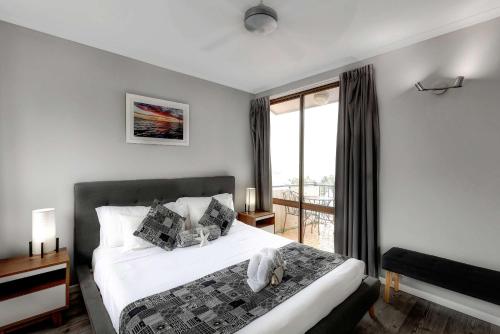 a bedroom with a bed and a large window at OCEAN VIEWS 16 pool & Spa Wi-FI in Airlie Beach