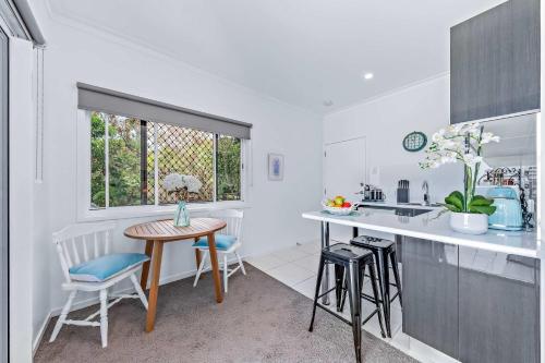 una cucina con tavolo, sedie e lavandino di Seascape Whitsundays ad Airlie Beach