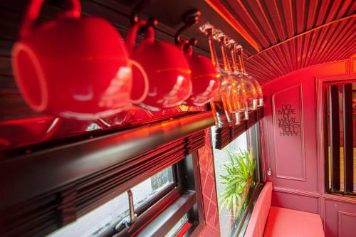 Una hilera de ollas y sartenes rojas colgando sobre una ventana en Baan Rot Fai Krabi Platform 1, en Ao Nang 