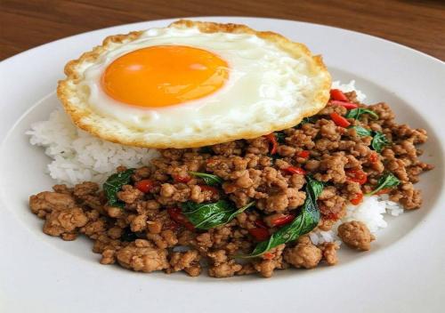 Un plato de comida con huevo frito y arroz. en Baan Tawan Homestay Koh Kood, en Ko Kood