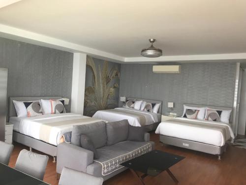 ein Hotelzimmer mit zwei Betten und einer Couch in der Unterkunft Exclusive Family Villa in Sampong