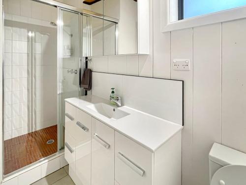 ein weißes Badezimmer mit Waschbecken und Dusche in der Unterkunft Doon It Right in Bonnie Doon