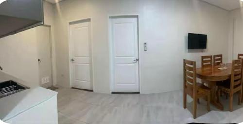 a kitchen and dining room with a table and white doors at Stay Inn Apartelle in Roxas City