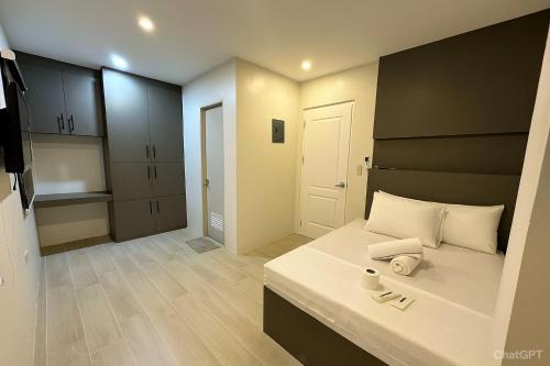 a small room with a bed and a kitchen at Stay Inn Apartelle in Roxas City