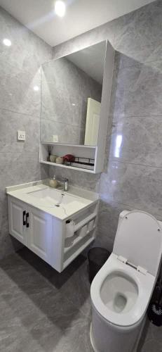 a bathroom with a white toilet and a sink at Alba Gardens in Gatunga
