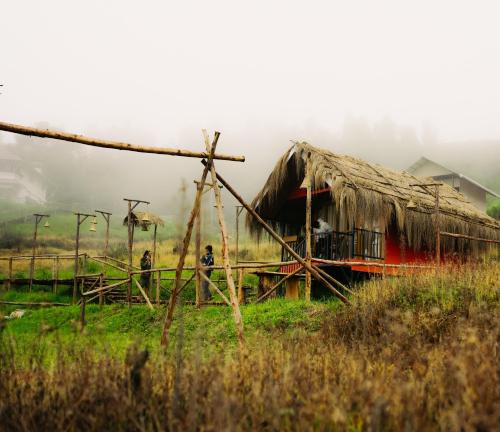 a hut in a field with two people standing outside at Elim Retreat kanthalloor in Kanthalloor