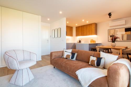 a living room with a couch and a chair at Stylish 2BR in Leça with AC by LovelyStay in Leça da Palmeira