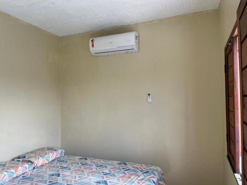 a bedroom with a bed and a air conditioner on the wall at Hostel dos amigos in Salinópolis