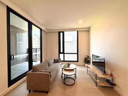 北克莱顿M-City Cozy Cloud Apartment near Hospitable&Monash的客厅里有一张沙发和一张桌子。