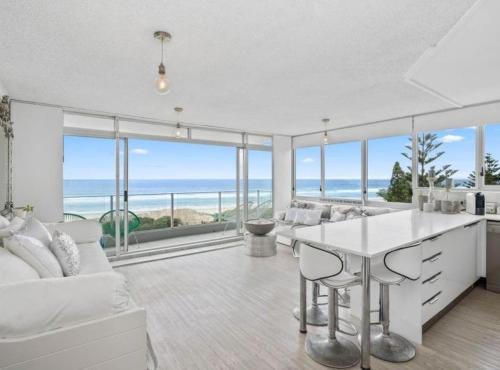 a kitchen and living room with a view of the ocean at Oceanfront Serenity At Main Beach in Gold Coast