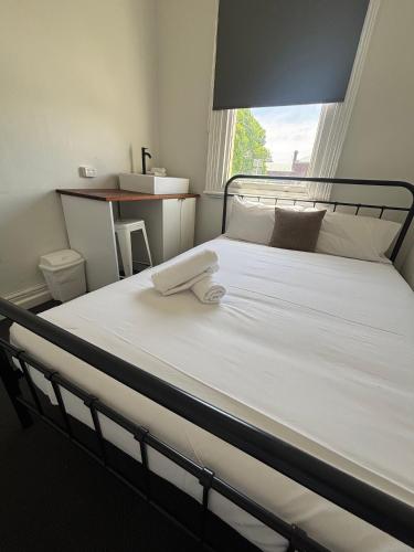 un grande letto bianco con un asciugamano sopra di Echuca Hotel a Echuca