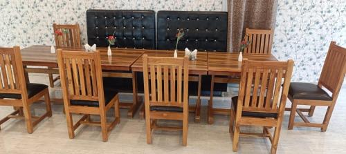 mesa de comedor de madera con sillas, mesa de madera y sillón en Hotel Annapurna Regency, en Mirzāpur