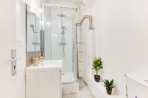 ein weißes Badezimmer mit Waschbecken und Dusche in der Unterkunft L'élégance - La Petite Provence & La belle époque - hyper centre in Dreux