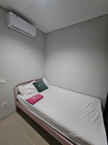 un piccolo letto in una stanza con aria condizionata di Omah Bubuya Syariah, Surabaya barat 