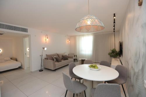埃拉特Sea Side Luxury- סי סייד的客厅里有一张白色的桌子和椅子