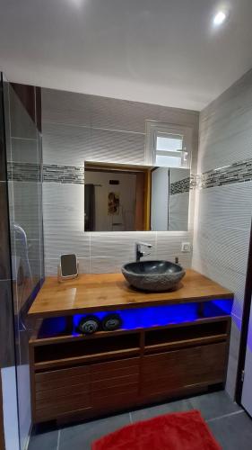 a bathroom with a counter with a sink and a mirror at Rêve créole "villa Claire" mer plage mini piscine in Deshaies