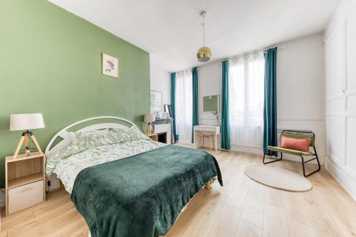 ein grünes Schlafzimmer mit einem Bett und einem Stuhl in der Unterkunft L'élégance - La Petite Provence & La belle époque - hyper centre in Dreux