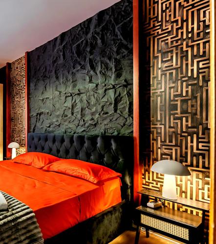 a bedroom with a red bed and a wall at Beachfront Central Boutique Apartments in Durrës