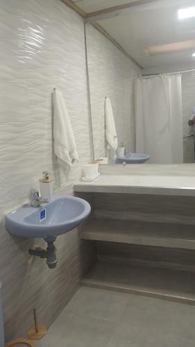 a bathroom with a sink and a tub and a mirror at Cabaña Villa Morena in Arroyo Hondo