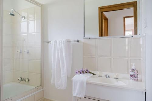 une salle de bain blanche avec un lavabo et un miroir dans l'établissement Paradise Lake, à Yatte Yattah