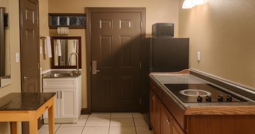 eine Küche mit einem schwarzen Kühlschrank und einer Spüle in der Unterkunft Gated 2 Double Beds Studio with Full Kitchen 102 in Baton Rouge