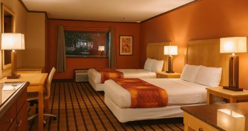 ein Hotelzimmer mit zwei Betten und einem Schreibtisch in der Unterkunft Gated 2 Double Beds Studio with Full Kitchen 102 in Baton Rouge