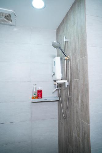 a shower with a shower head on a wall at Arte Plus Luxury Suites with KLCC View in Kuala Lumpur