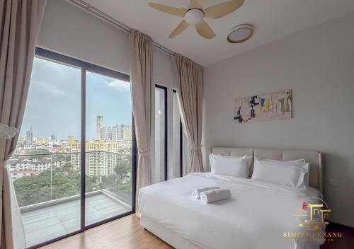 ein Schlafzimmer mit einem weißen Bett und einem großen Fenster in der Unterkunft Beacon Executive Suites in George Town