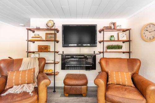 a living room with two chairs and a flat screen tv at Uptown 1 Bedroom Flat Near the Boise Train Depot in Boise