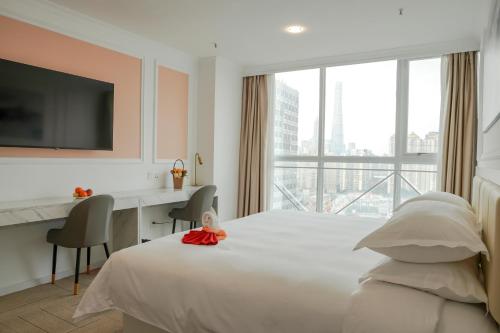 a bedroom with a bed with a desk and a large window at Magnificent International Hotel in Shanghai