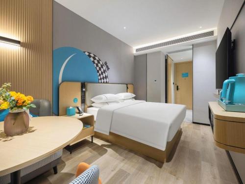 a hotel room with a bed and a table at City Comfort Inn Zhongshan Lihe Square Walmart Branch in Zhongshan