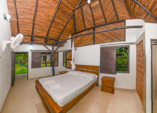 a bedroom with a bed in a room with windows at Hostal La Media Luna Palomino in Palomino