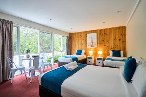 une chambre d'hôtel avec deux lits, une table et des chaises dans l'établissement Sanctuary House Resort Motel, à Healesville